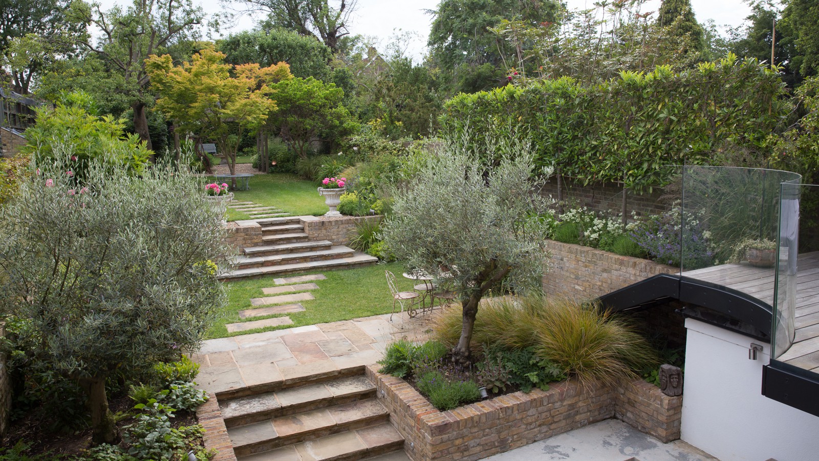 Ancient Olive trees framing the view down the garden from balcony, while pleached laurels elegantly screen the boundaries