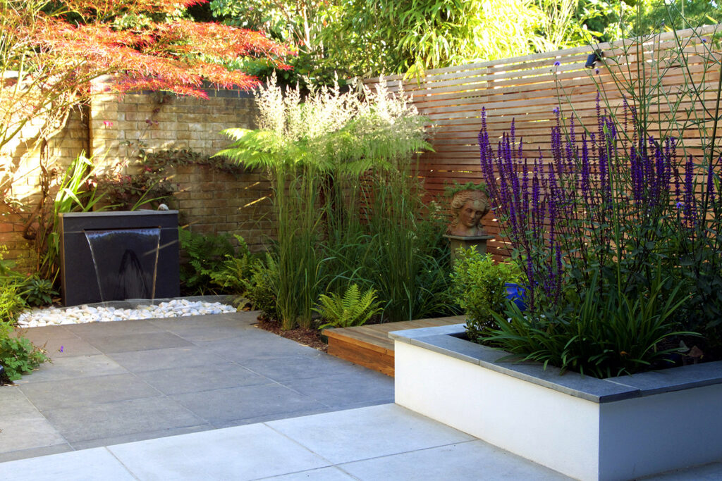 Water blade feature and sculpure nestled in simple planting scheme